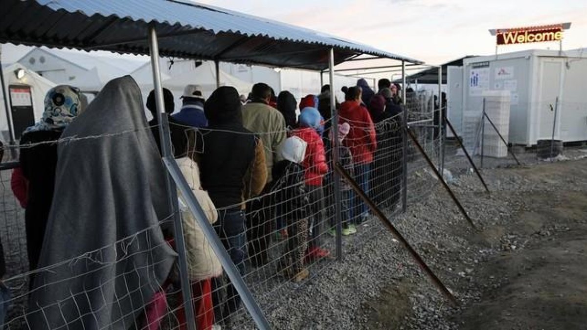 Refugiados y migrantes hacen cola durante la distribución de comida en un campamento cercano a Idomeni, en la frontera de Grecia con Macedonia, este jueves.-REUTERS / YANNIS BEHRAKIS