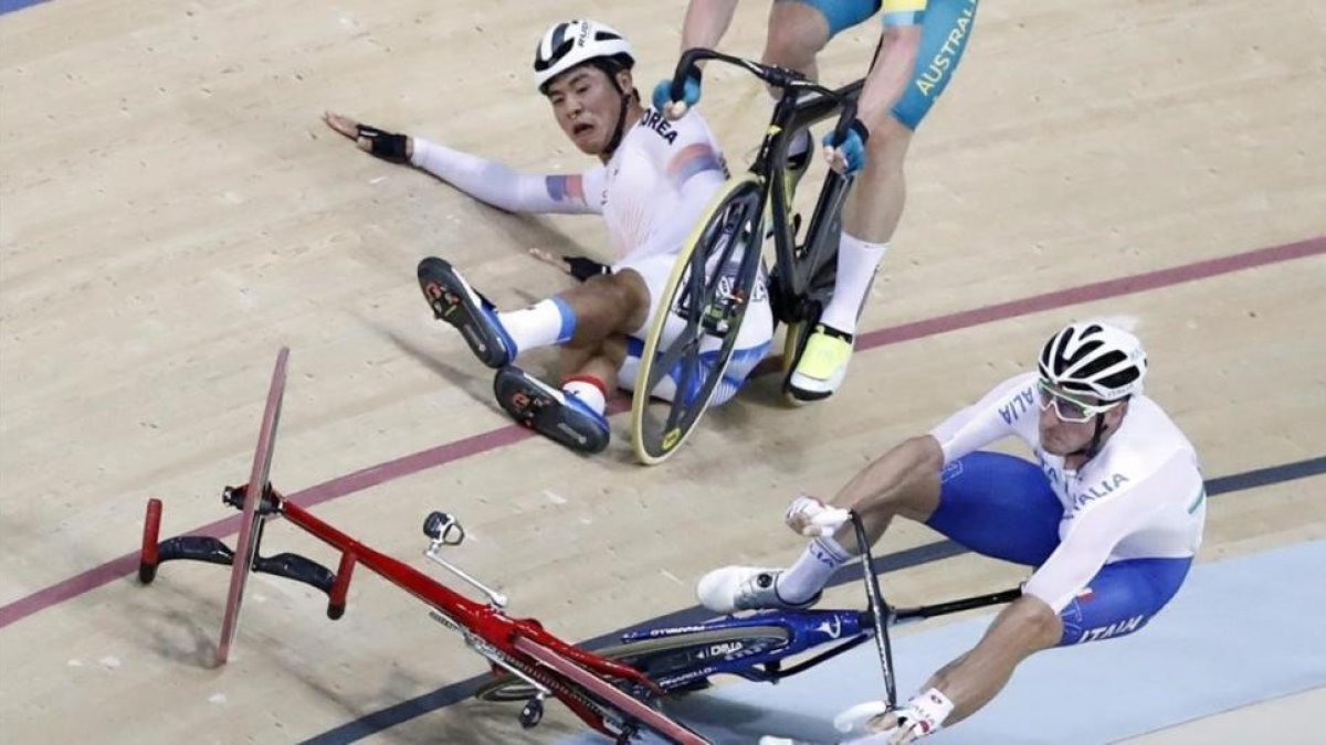 El italiano Elia Viviani y el surcoreano Sanghoon Park chocan y caen durante la prueba de omnium de ciclismo en pista.-JAVIER ETXEZARRETA / EFE
