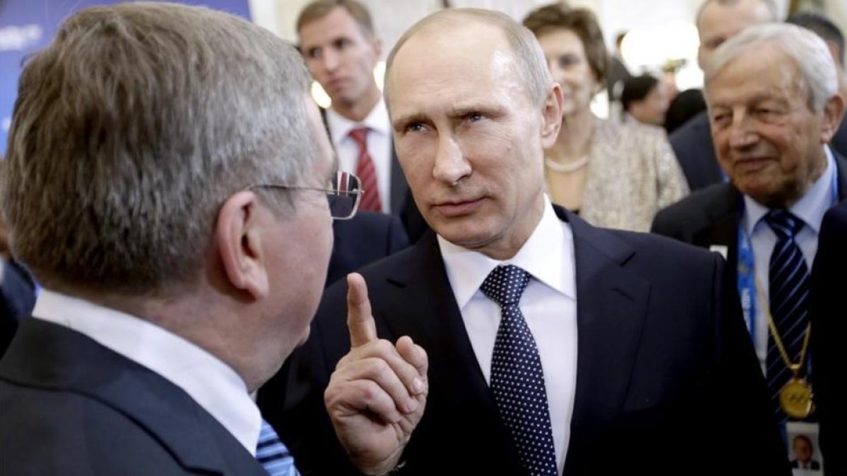 El presidente ruso, Vladímir Putin, habla con su homólogo del COI, Thomas Bach, durante los Juegos de Sochi.-AP / DAVID GOLDMAN
