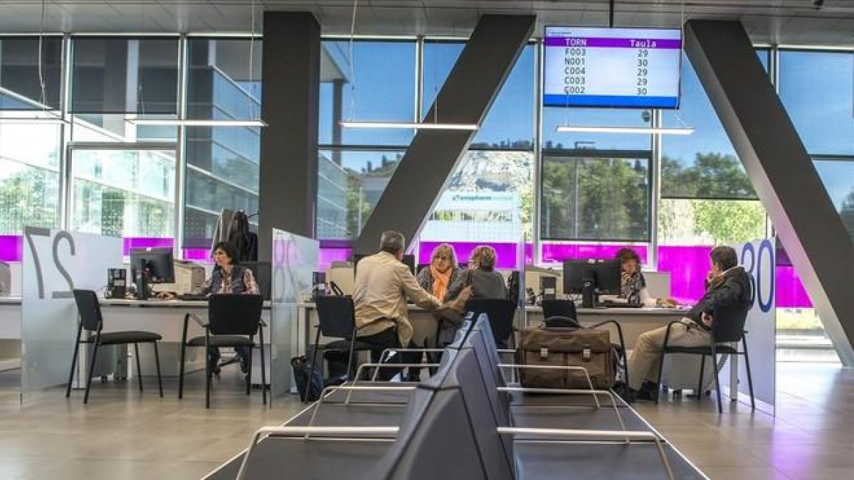 Empleados públicos atienden a contribuyentes en una sede de la Agencia Tributaria de Cataluña.-FERRAN SENDRA