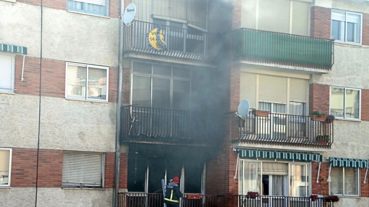 Un bombero interviene en la vivienda siniestrada en Cuéllar.-ICAL