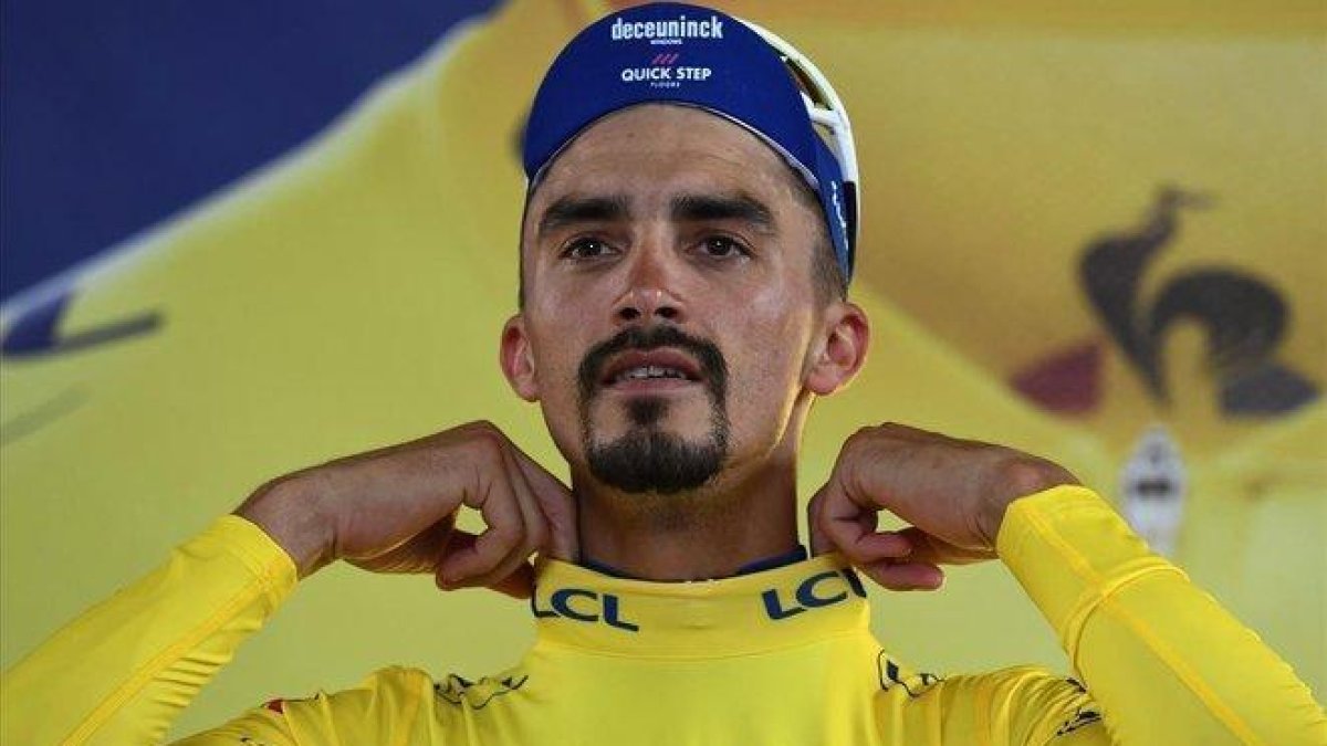 Julian Alaphilippe se ajusta el jersey amarillo en el podio de Toulouse.-ANNE-CHRISTINE POUJOULAT / AFP