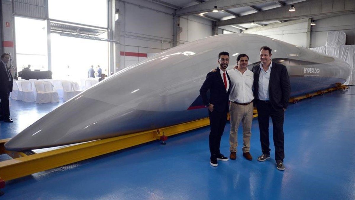 Los directivos de la empresa que ha diseñado el tren del futuro frente al vagón que se ha presentado.-AFP