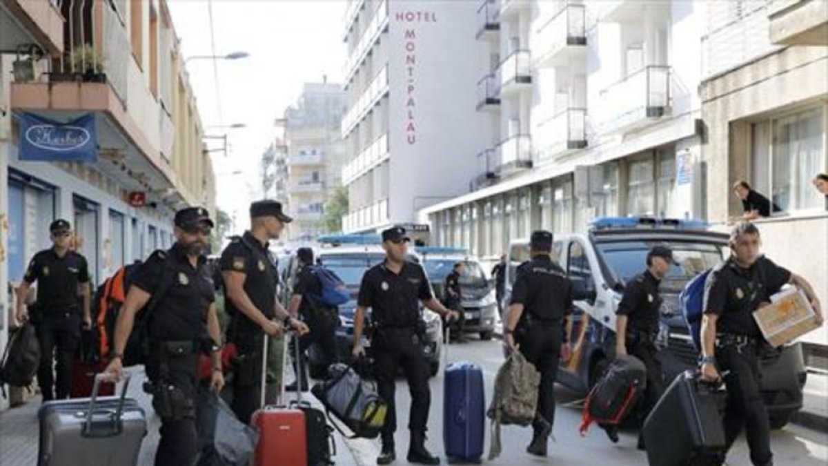 Policías nacionales cuando abandonaron el hotel de Pineda de mar en el que se alojaban tras el 1-O.-/ EFE / ANDREU DALMAU