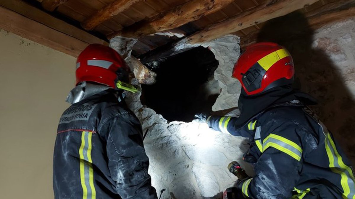 Los bomberos durante su intervención en la casa rural incendiada en Castillejo de Robledo.