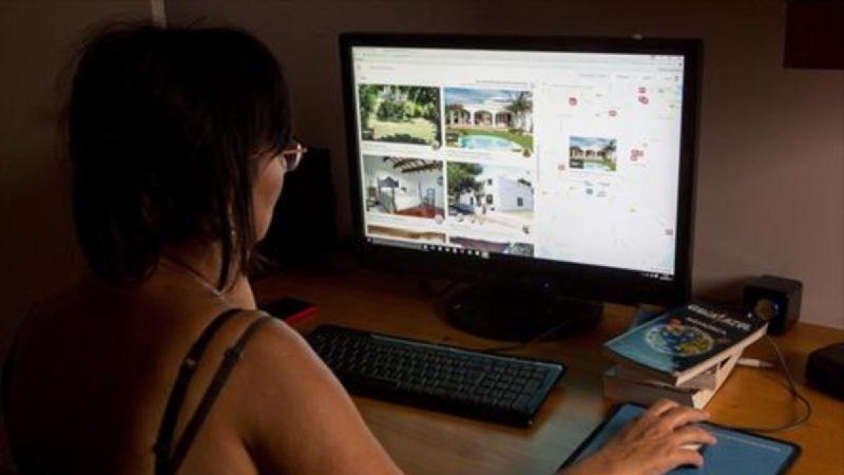 Una usuaria navega en la web especializada Airbnb.-FERRAN NADEU