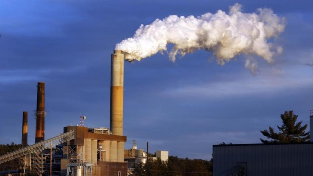 Una columna de humo sale de una industria en Estados Unidos.-JIM COLE
