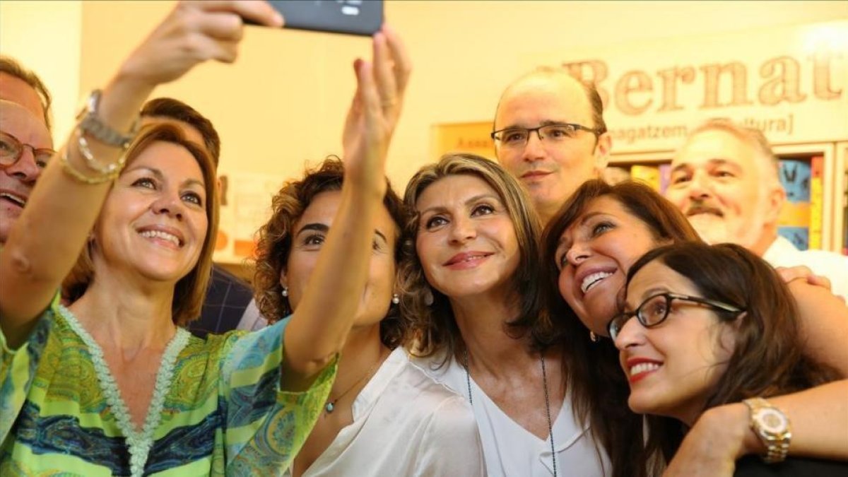 María Dolores de Cospedal, acompañada de la ex ministra Dolors Montserrat, fotografiándose con afiliados y simpatizantes en la sede del PP en Barcelona.-RICARD CUGAT