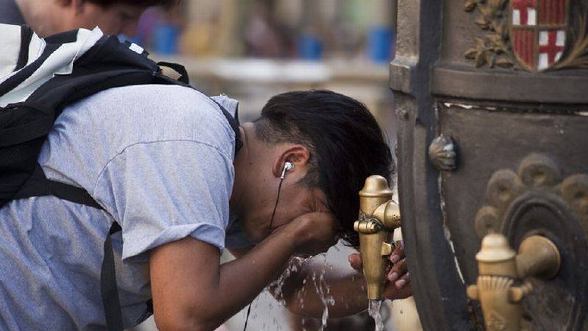 Un turista se refresca en la fuente de Canaletes durante una ola de calor.-Foto:   ARCHIVO / JOAN PUIG
