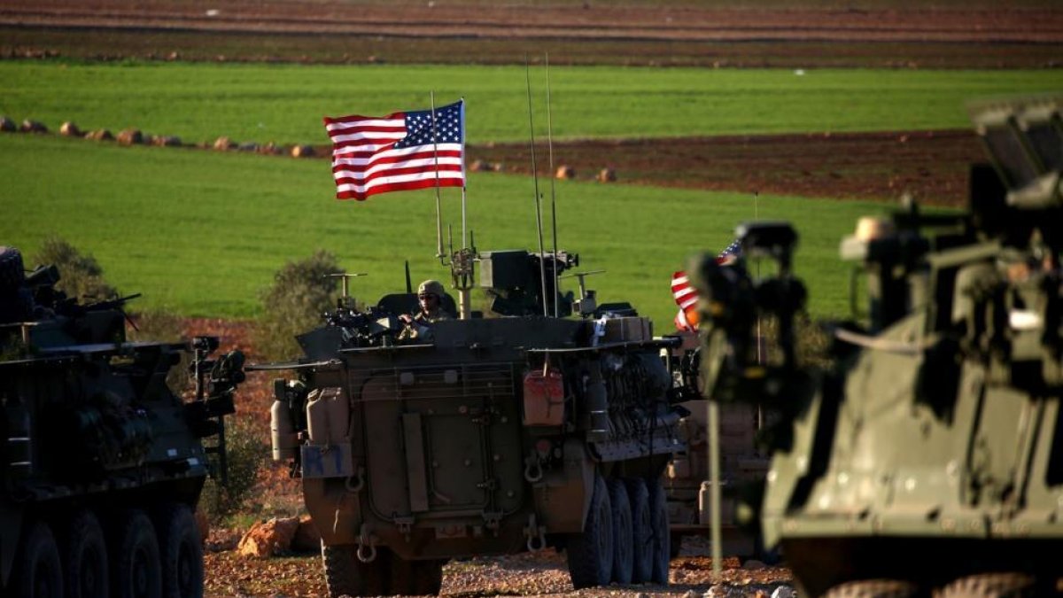 Un convoy de tanques con bande ra de EEUU circulan a las afueras de la ciudad de Manbij, al norte de Siria.-AFP