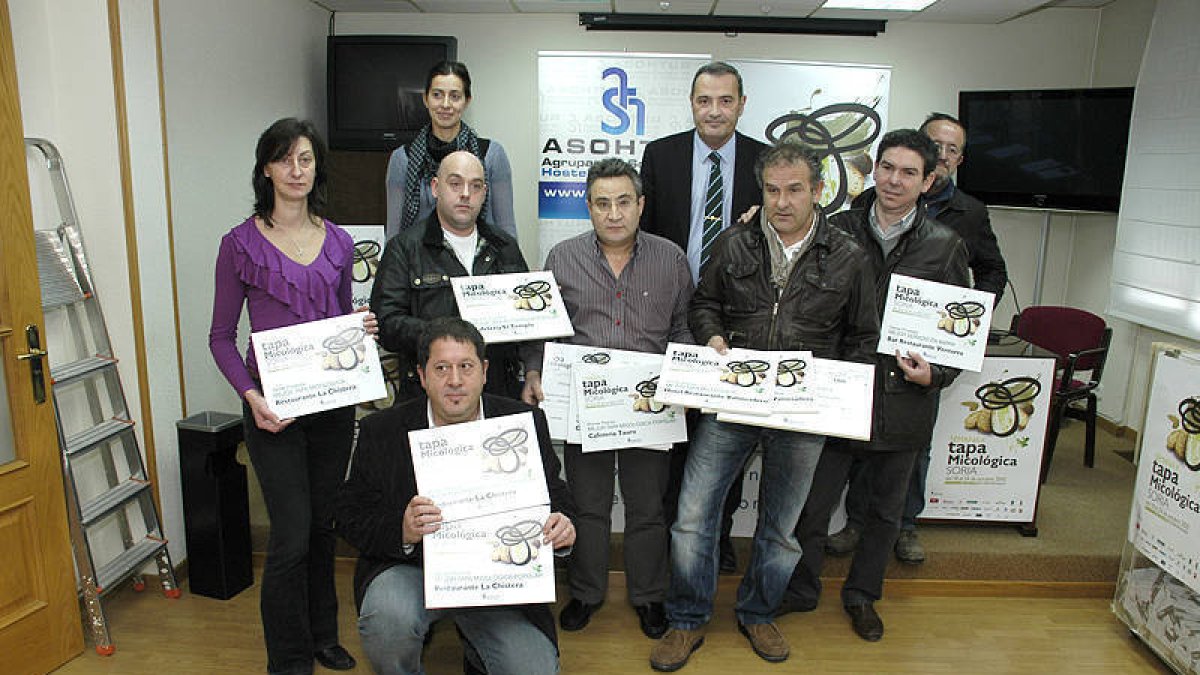 Foto de familia de todos los ganadores y los finalistas posando con Ángel Mayor y con los títulos del III Concurso de la Tapa Micológica. / ÁLVARO MARTÍNEZ-