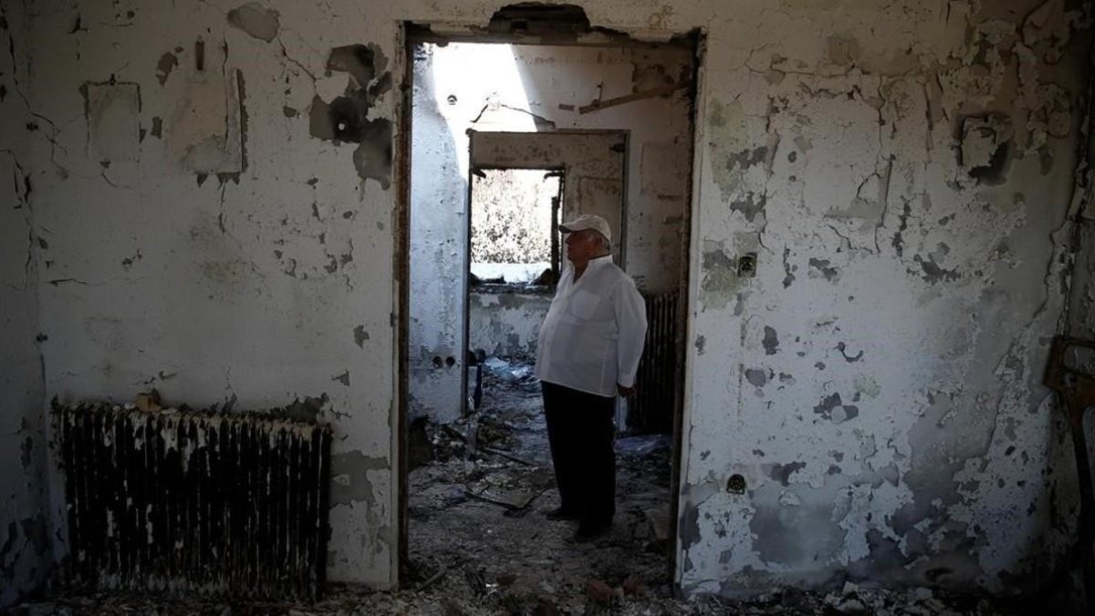 Un hombre en su casa quemada de Mati. /-REUTERS / COSTAS BALTAS