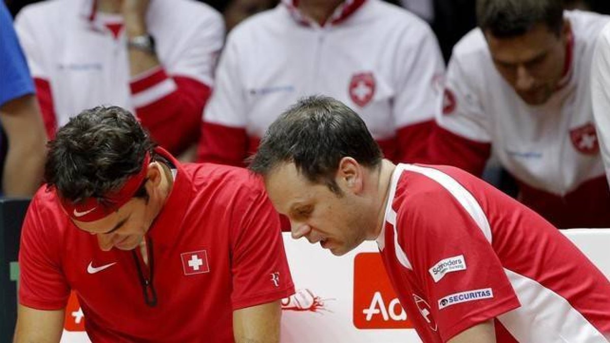 Federer escucha la sinstrucciones del capitán suizo, Severin Luthi, en un descanso de su duelo con Monfils. AP / CHRISTOPHE ENA Federer escucha la sinstrucciones del capitán suizo, Severin Luthi, en un descanso de su duelo con Monfils.-AGENCIAS