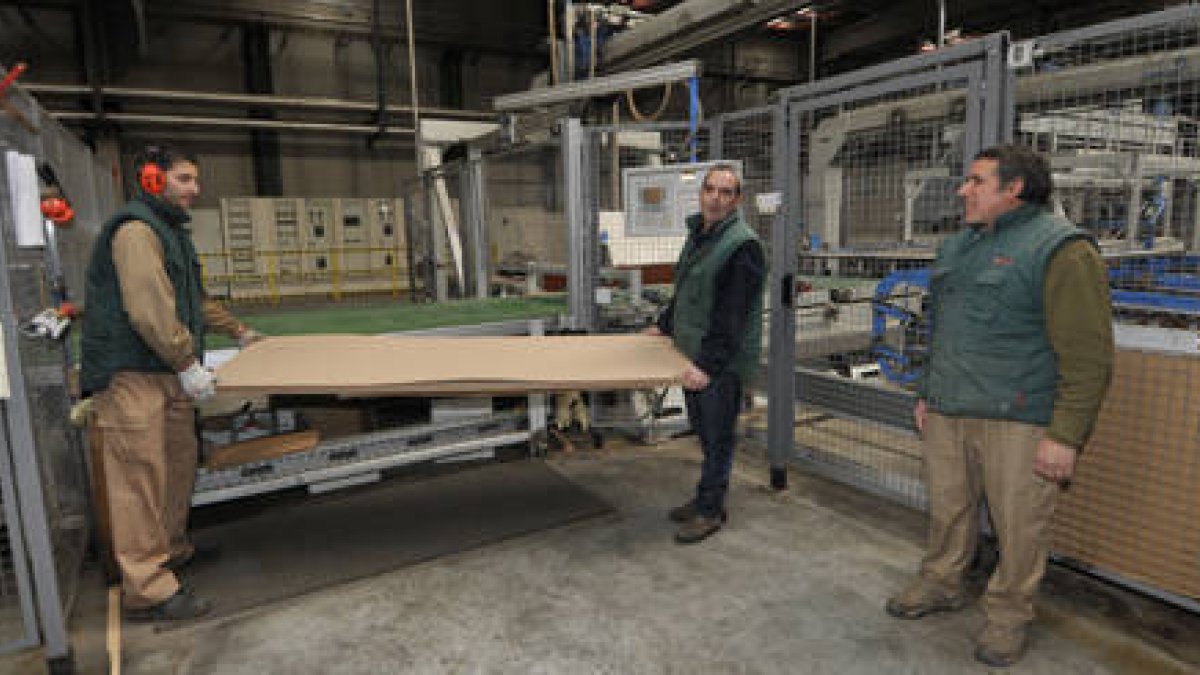 Los primeros trabajadores sacan un panel ya con las chapas colocadas. / VALENTÍN GUISANDE-