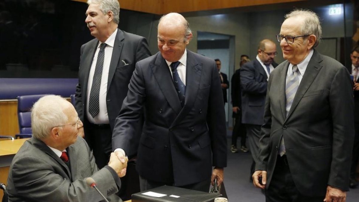 El ministro Luis de Guindos saluda a su homónimo alemán, Wolfgang Schauble.-JULIEN WARNAND