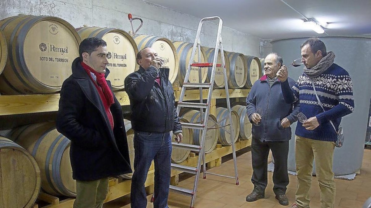 Los bodegueros y enólogos Rubén Gago (i), Antonio Ferrero, a su lado, y David Mendieta (d) catan unos vinos en barrica.-M. D.