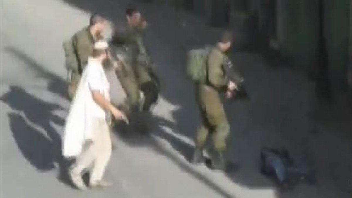 Un colono, con un pistola, tras abatir a un palestino en Hebrón.-