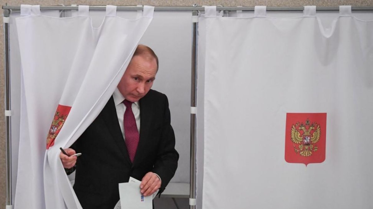 Vladimir Putin se dispone a depositar su voto en las elecciones presidenciales rusas.-/ YURI KADOBNOV POOL POOL (EFE)