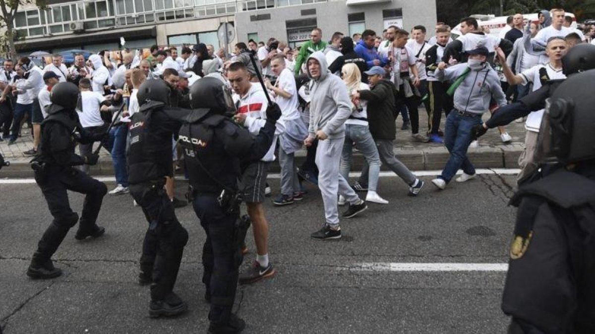 Aficionados del Legia se enfrentan a agentes de la Policia Nacional antes del comienzo del partido del martes contra el Madrid.-EFE / BARTLOMIEJ ZBOROWSKI