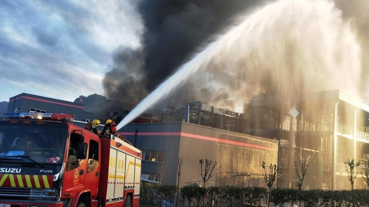 Los bomberos durante las tareas de extinción del incendio, este jueves en China.-STR