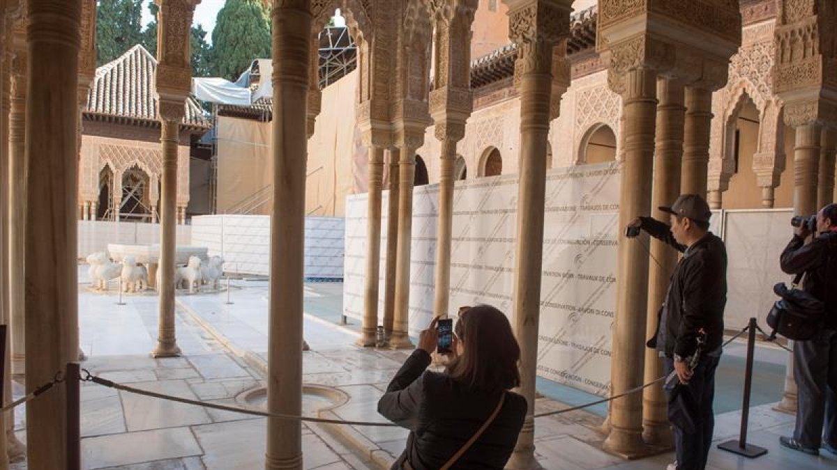 Unos turistas fotografían el Patio de los Leones de la Alhambra de Granada.-EFE/Archivo