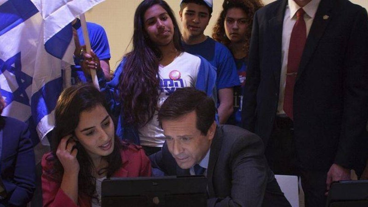 Herzog, líder de los laboristas, consulta datos en un ordenador junto a miembros del movimiento juvenil Dror, en una visita a colegios electorales en Tel-Aviv.-Foto: EFE / ANNA LOSHKIN