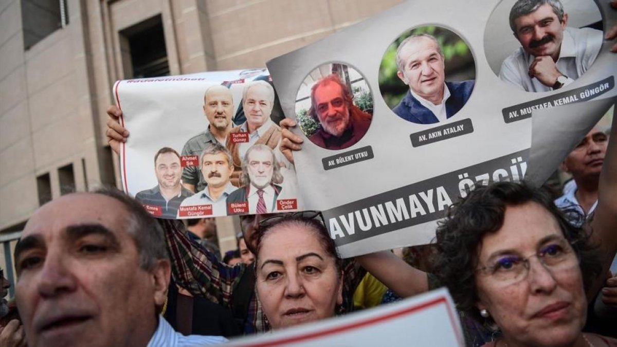 Un grupo de manifestantes muestran imágenes de periodistas del diario opositor Cumhuriyet, en una protesta en Estambul, el 28 de julio.-AFP / OZAN KOSE