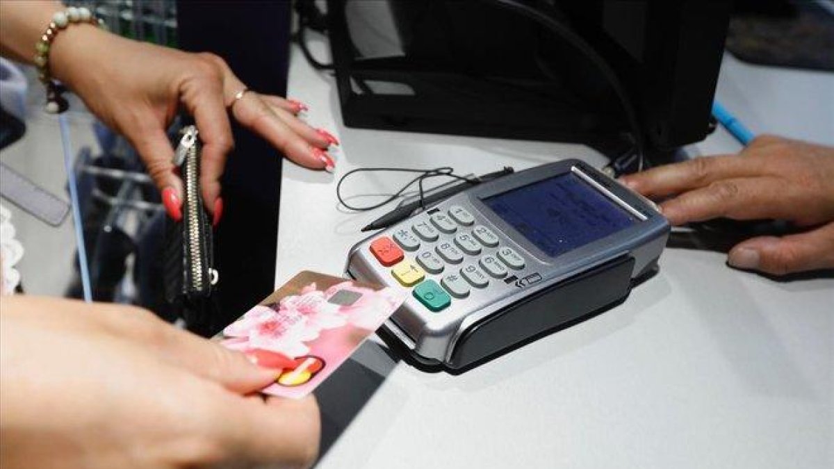 Un cliente realizando un pago con un tarjeta en un comercio.-FERRÁN NADEU