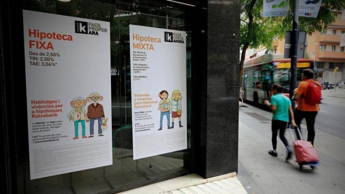 Oficina de una entidad bancaria con publicidad sobre hipotecas.-FERRAN NADEU
