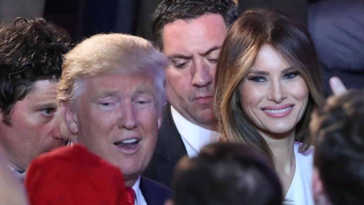 Trump y su mujer, Melania, felicitados por la multitud tras el discurso de aceptación de la victoria del magnate, en el hotel New York Hilton Midtown, en Nueva York, el 9 de noviembre.-AFP / MARK WILSON