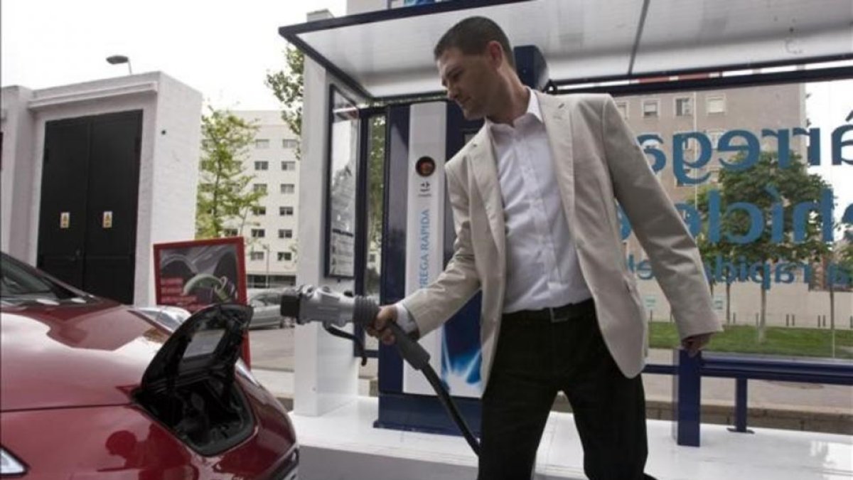 Un conductor carga su coche eléctrico en un punto de recarga de Barcelona.-DANNY CAMINAL