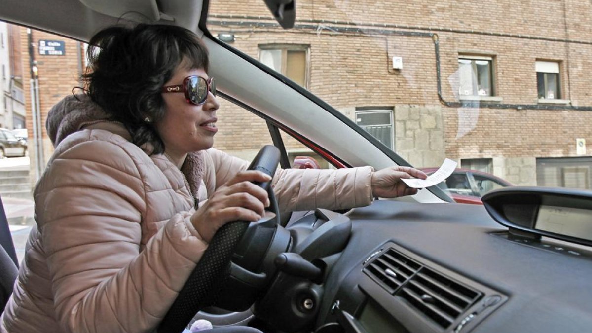 Una conductora coloca el comprobante de la zona azul en su coche.-Mario Tejedor