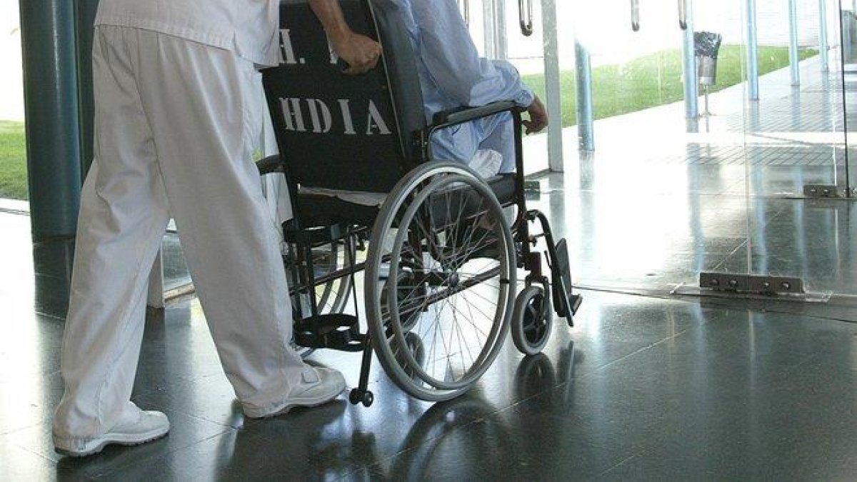 Un enfermo en silla de ruedas en un hospital.-