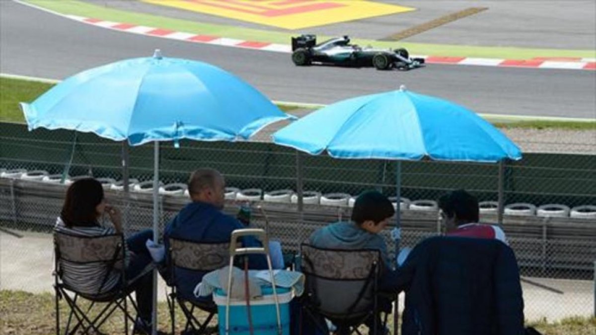 Una familia sigue la competición clasificatoria, ayer, en el circuito de Montmeló.-AFP