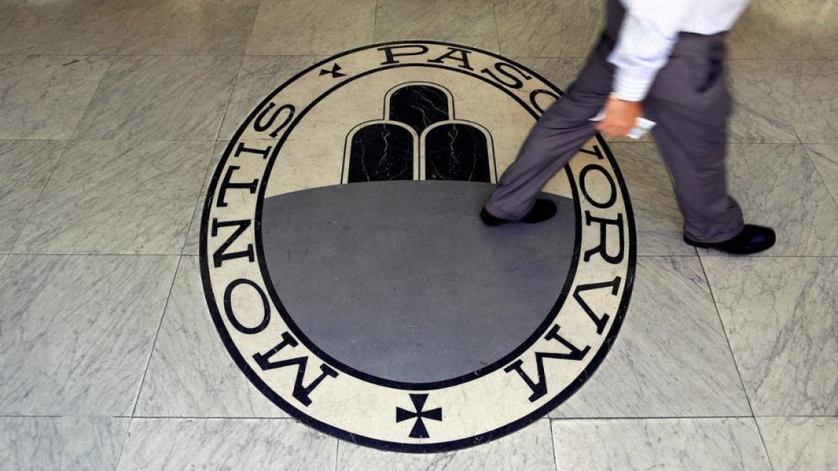 Un hombre camina sobre el logo del banco Monte Dei Paschi Di Siena en Roma.-ARCHIVO / REUTERS / REUTERS