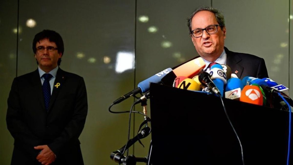 Quim Torra, en primer plano, y Carles Puigdemont, al fondo, en la rueda de prensa de este martes en Berlín.-/ AFP / TOBIAS SCHWARZ