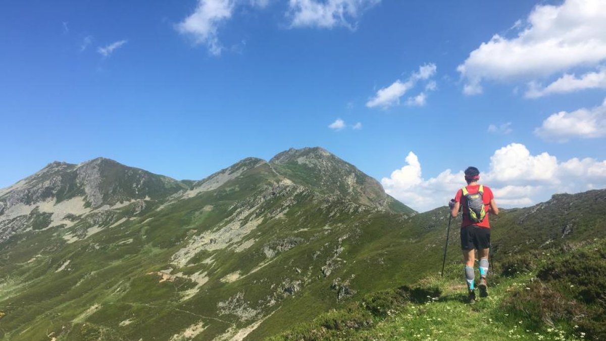 Un montañero transita por el cordal con las cumbres del Cebolleda y Gildar al fondo-N.S.