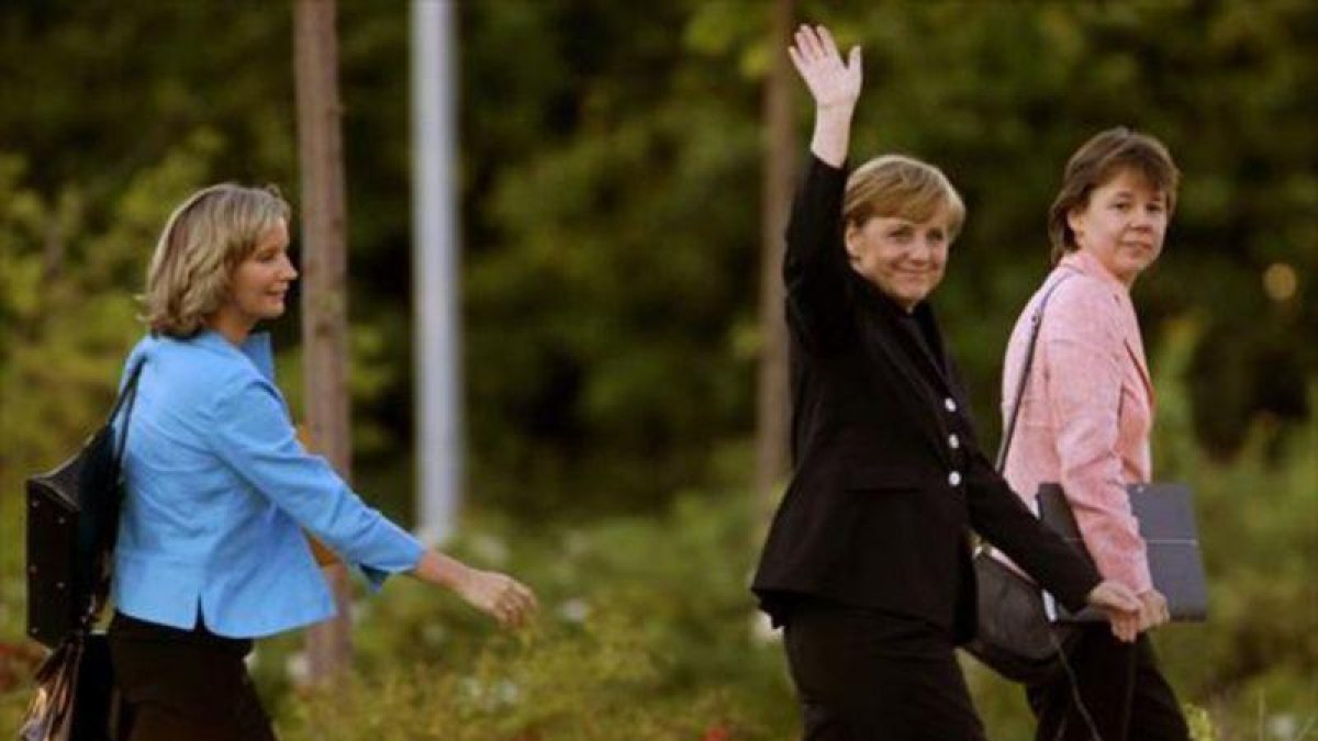 Angela Merkel, custodiada por Beate Baumann (derecha) y Eva Christiansen, a la llegada de la cancillera a un estudio de TV de Berlín.-REUTERS / ARND WIEGMANN