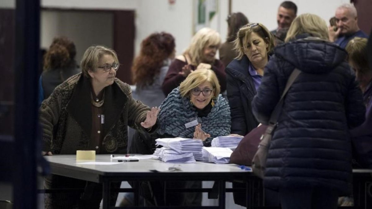 Miembros de una mesa electoral abren los sacos con las papeletas del referéndum.-EFE / MASSIMO PERCOSSI