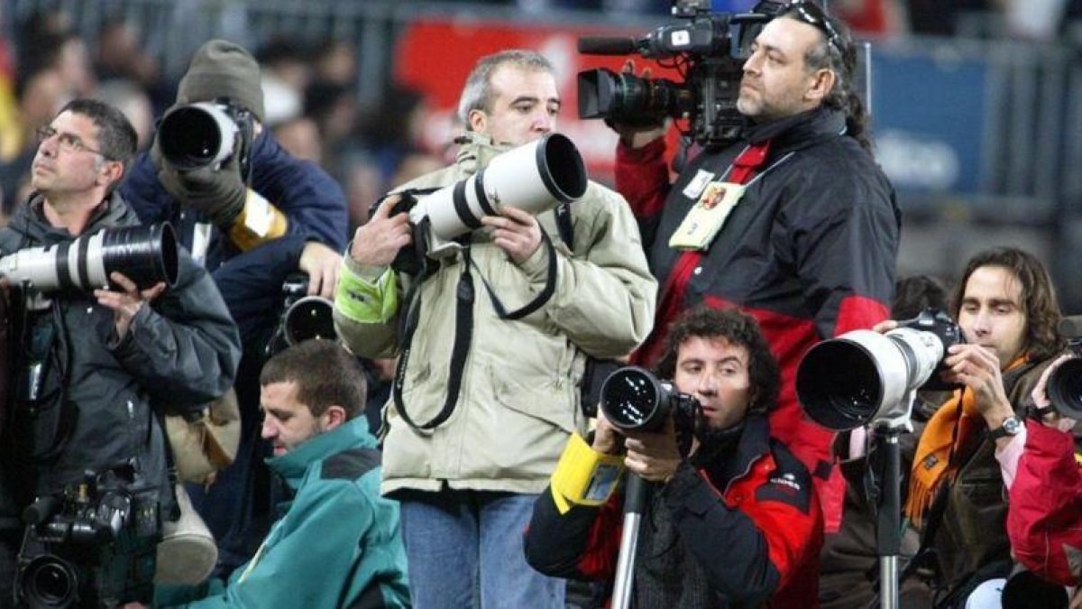 Grupo de fotoperiodistas en el césped del Camp Nou.-JORDI COTRINA