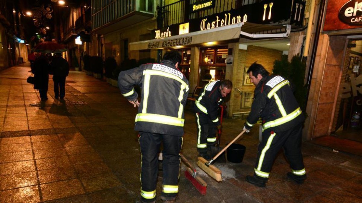 Bomberos limpiando el suelo de sangre y gasolina en la plaza Mayor el día que ocurrieron los hechos.-ÁLVARO MARTÍNEZ