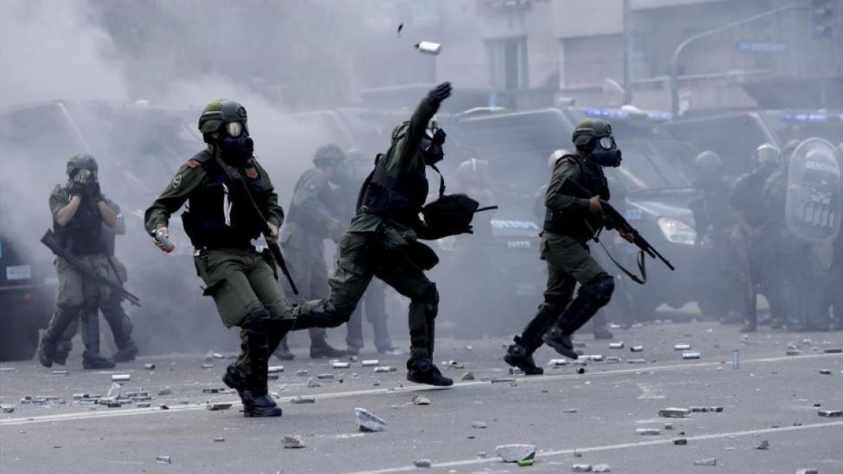 Policías lanzan botes de gas lacrimógeno contra los manifestantes que les lanzaron piedras y latas en las inmediaciones del Congreso, en Buenos Aires, el 14 de diciembre.-AP