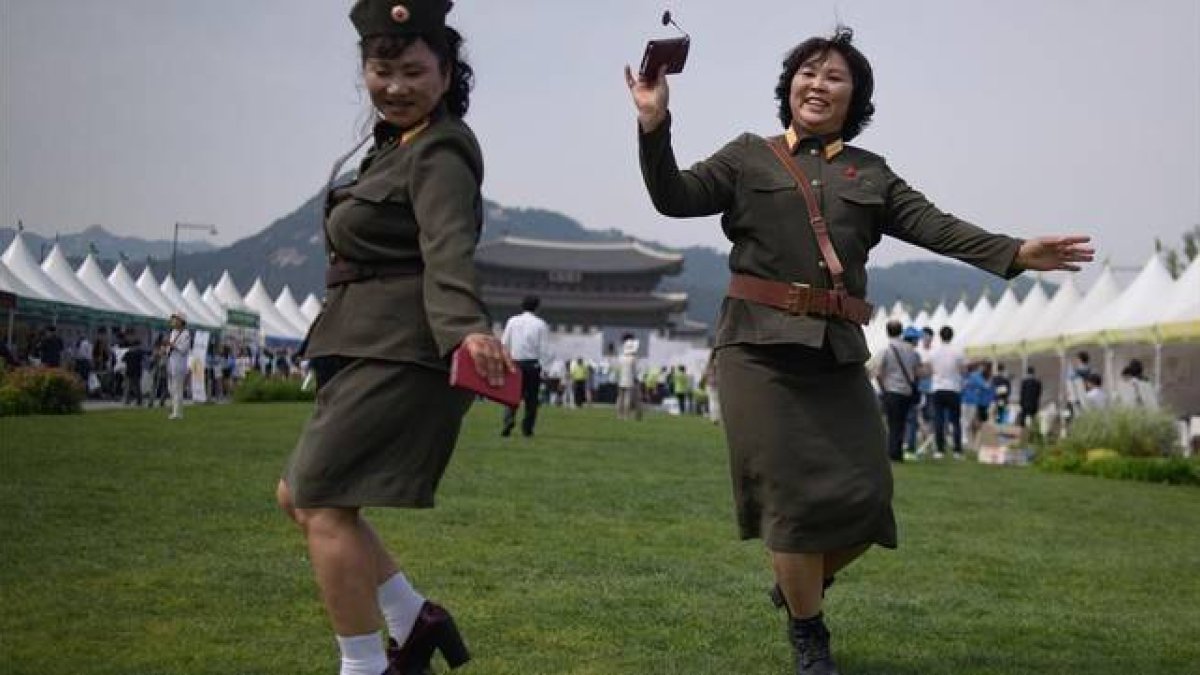 Desertoras de Corea del Norte bailan con uniformes militares de su país de origen en una exposición por la unificación de las dos Coreas, en Seúl, este viernes.-Foto:  AFP / ED JONES