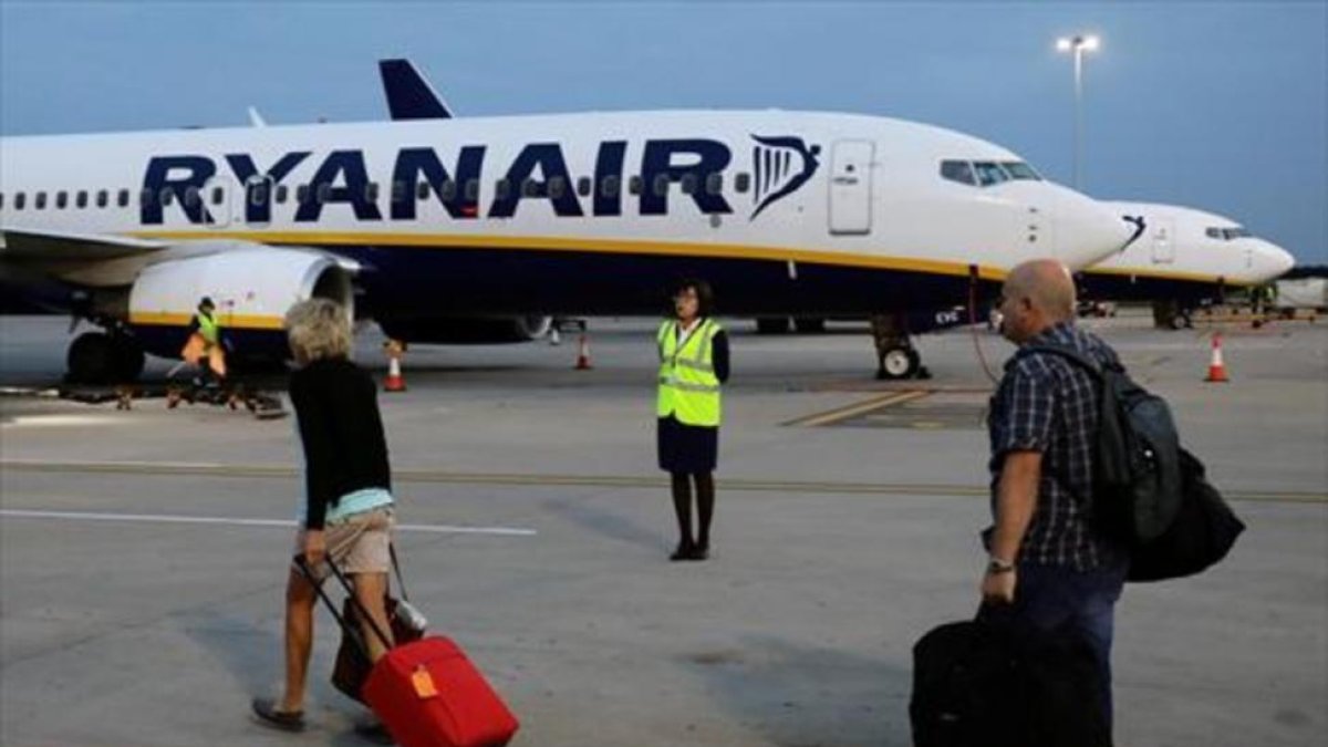 Pasajeros de Ryanair trasladando el equipaje a la aeronave.-REUTERS / KEVIN COOMBS