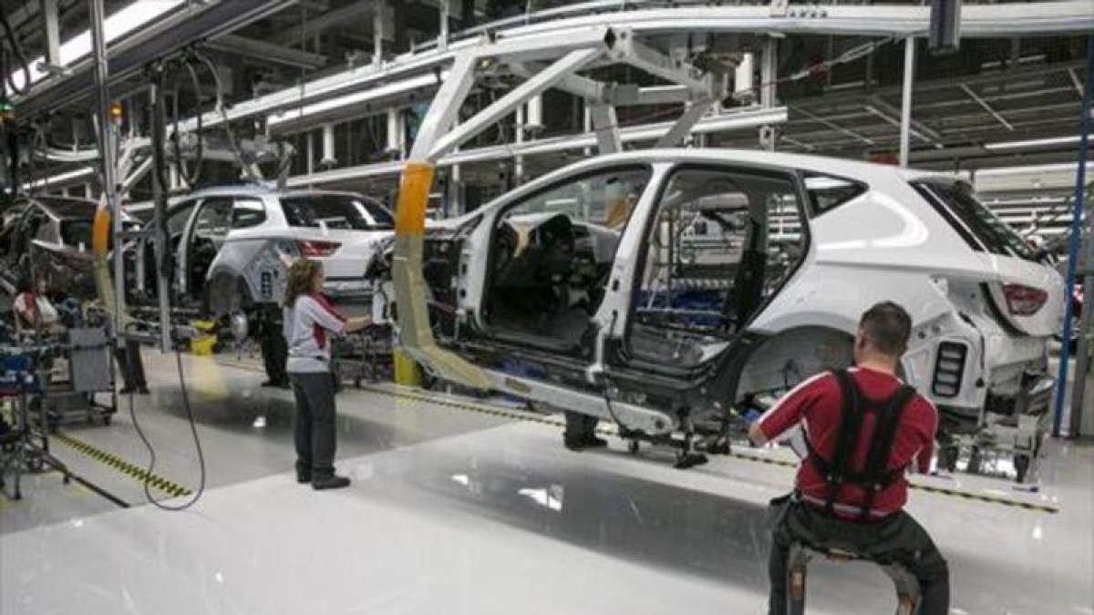 Operarios en una cadena de montaje de una empresa automovilística.-JOAN CORTADELLAS