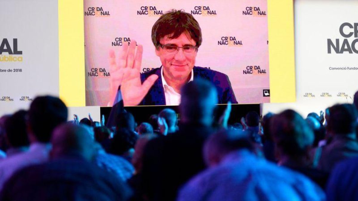 Puigdemont saluda desde la gran pantalla del acto fundacional de la Crida que se ha celebrado este sábado en el pabellón Nou Congost de Manresa.-AFP
