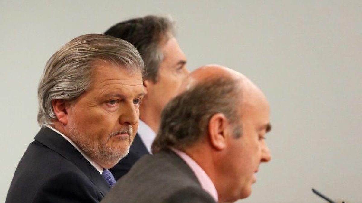 El ministro de Economía, Luis de Guindos, con el portavoz del Ejecutivo, Íñigo Méndez de Vigo, y el titular de Fomento, Íñigo de la Serna, este viernes en la rueda tras el Consejo de Ministros.-JUAN MANUEL PRATS