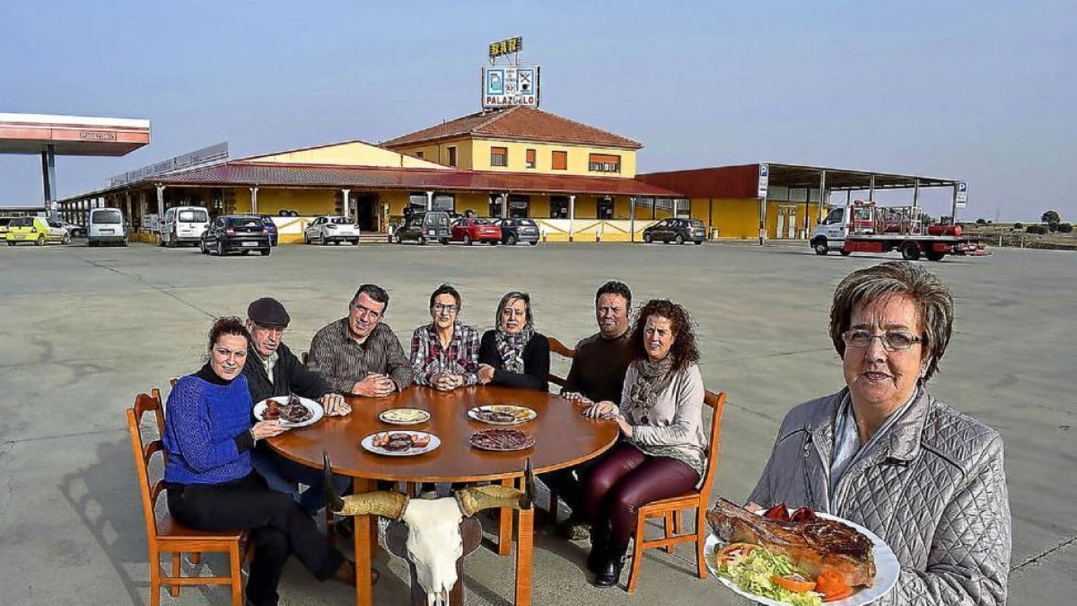 Mari Carmen Amez, en primer término, con un chuletón de búfalo, y su familia detrás. De i. a d.: Miriam, Carlos, Eduardo, Camino, Laura, Juan y Ana-Argicomunicación