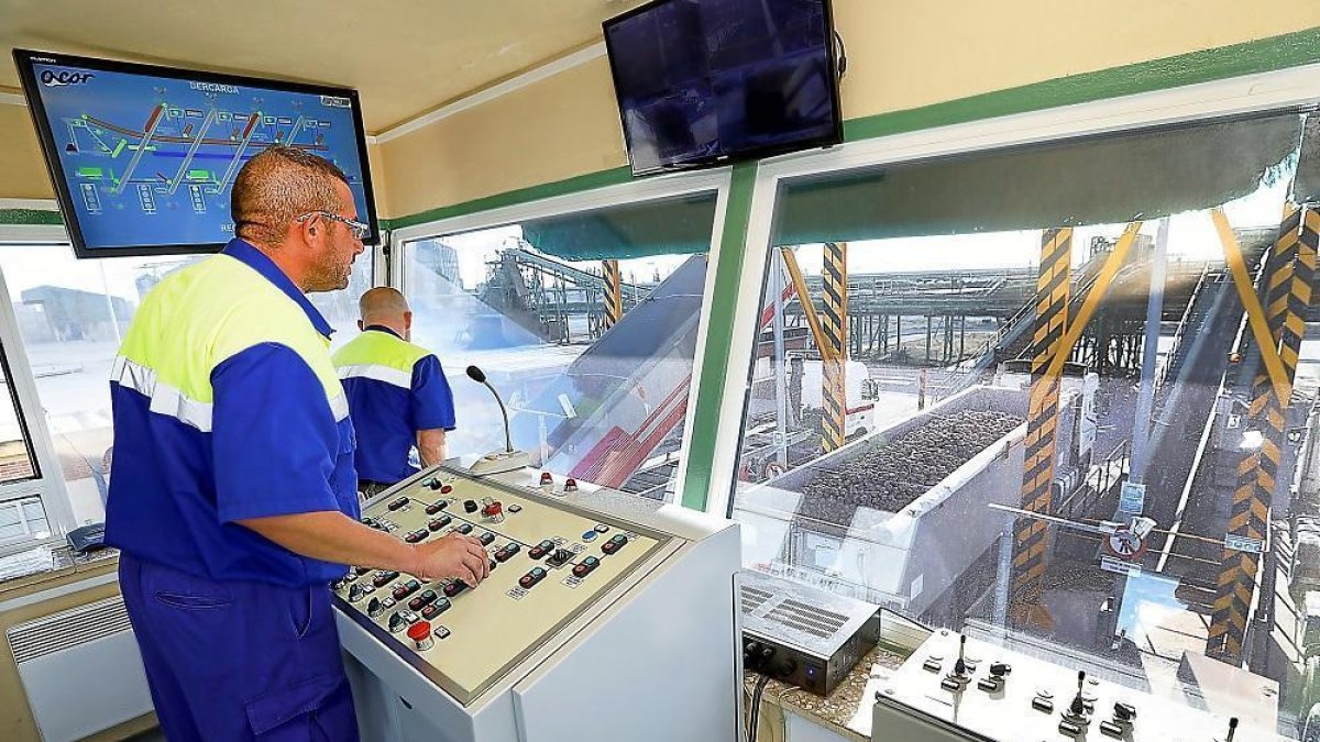 Dos operarios controlan la entrada de camiones que esperan la entrega durante la campaña de remolacha en las instalaciones de la cooperativa Acor, en la localidad vallisoletana de Olmedo.-- J.M. LOSTAU
