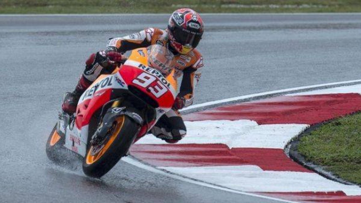 Marc Márquez, sobre el asfaltado mojado del circuito de Sepang.-Foto: EFE / AHMAD YUSNI